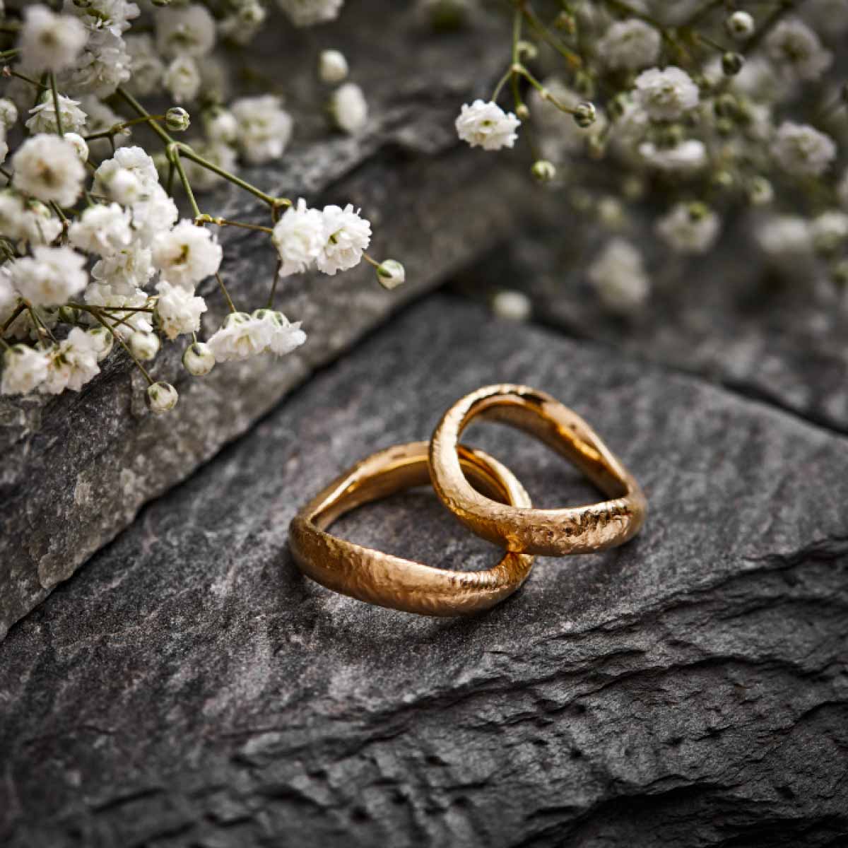 vielsesringe-i-roedguld-med-boelgeform-og-ujaevn-overflade